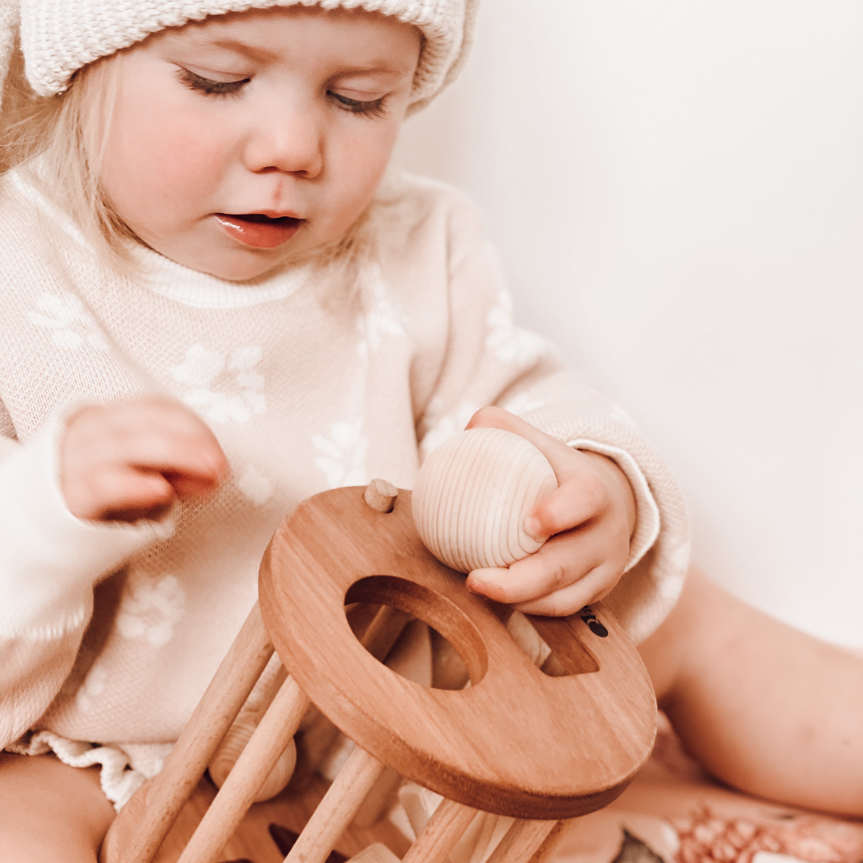 Baby playing with a wooden shape sorter from QTOYS