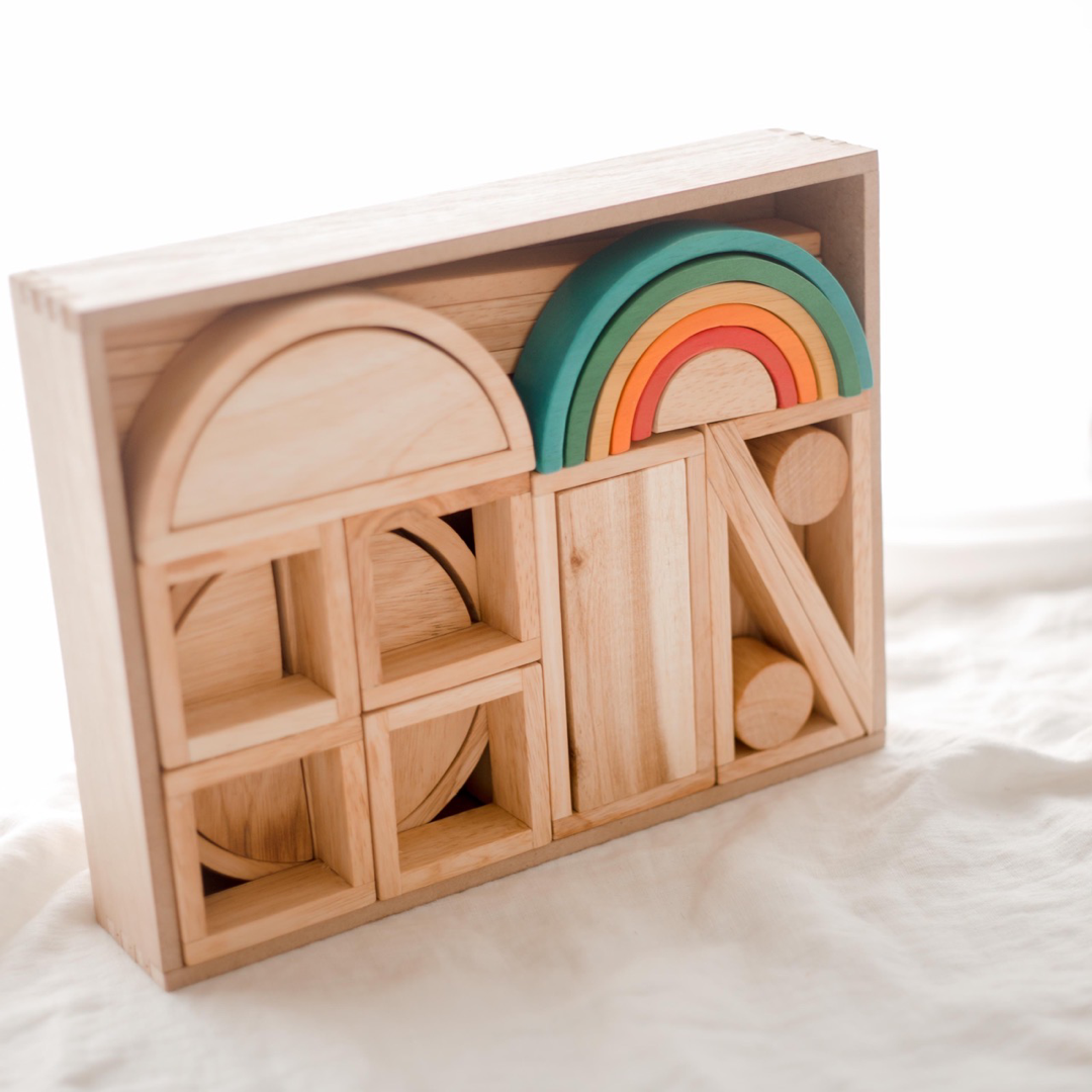 Wooden building blocks from QToys complete with a colourful wooden rainbow. Combination of hollow shapes, wooden planks and solid blocks.