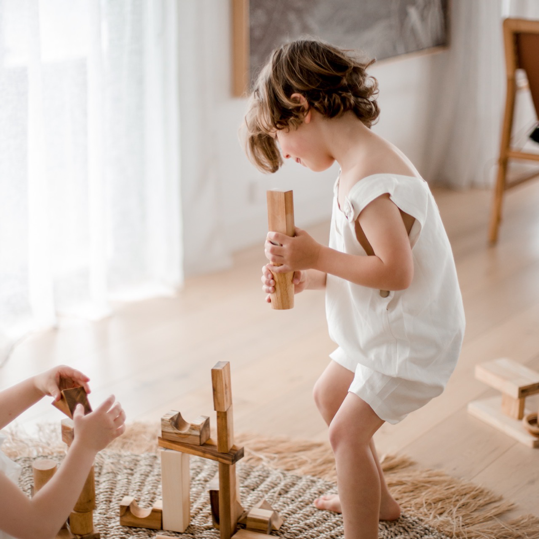 Children building a tall tower with QToys project blocks wooden building blocks