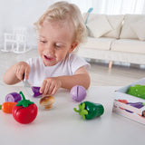 Boy engaging in role play cutting egg plant with pretend knife