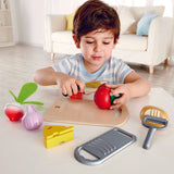 Boy chopping tomato of Hape cooking essentials play set.