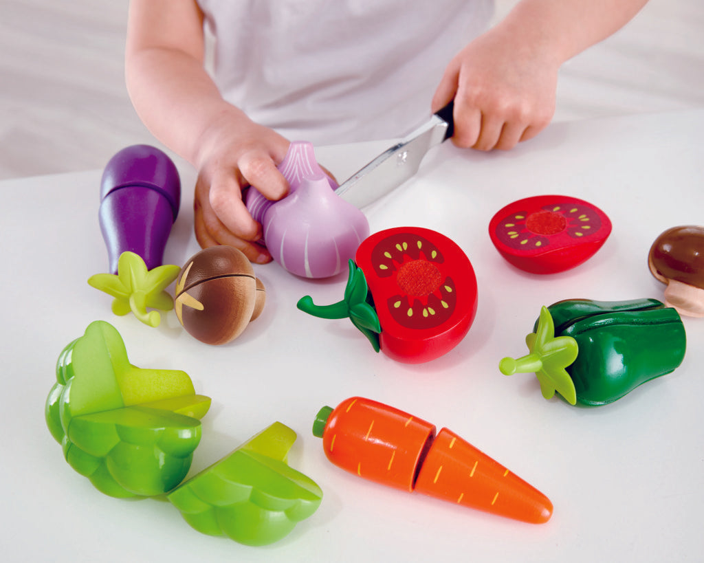 Wooden pretend play food being cut in half during role play
