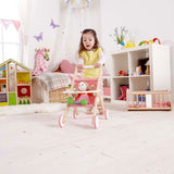Girl pushing doll around in Hape stroller