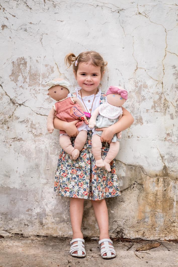 Young girl holding baby Aria and friend doll from Bonikka doll range by Tikiri Toys looking very happy
