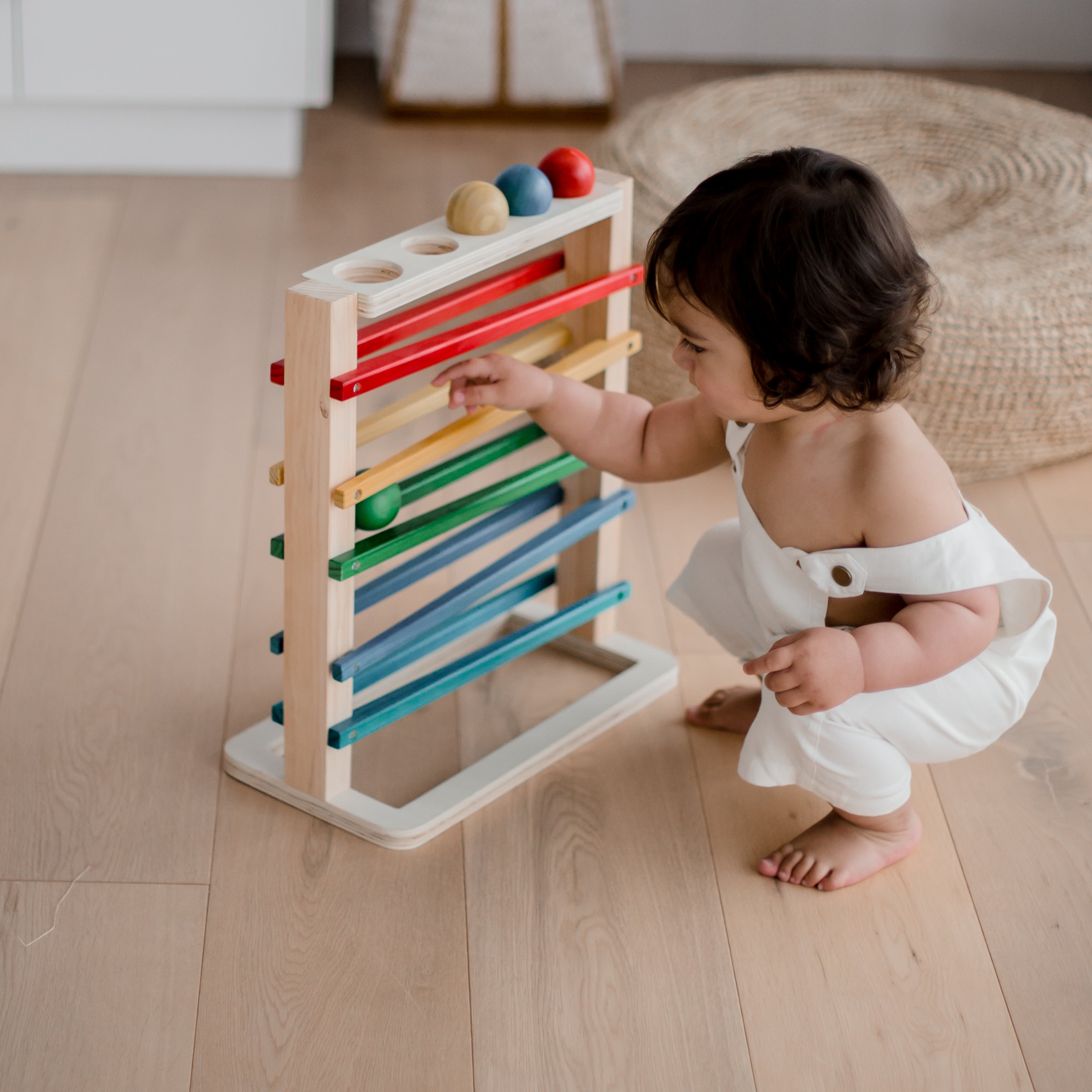 Child playing with QToys track a ball rack