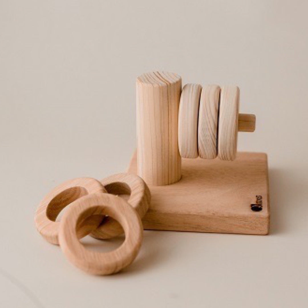 A wooden horizontal stacker from Qtoys, with 3 smaller rings and 3 larger rings