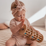 Baby playing with wooden rain maker with colourful wooden balls from QToys