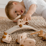 Boy driving his car over a bridge from wooden Vehicle play set from QToys