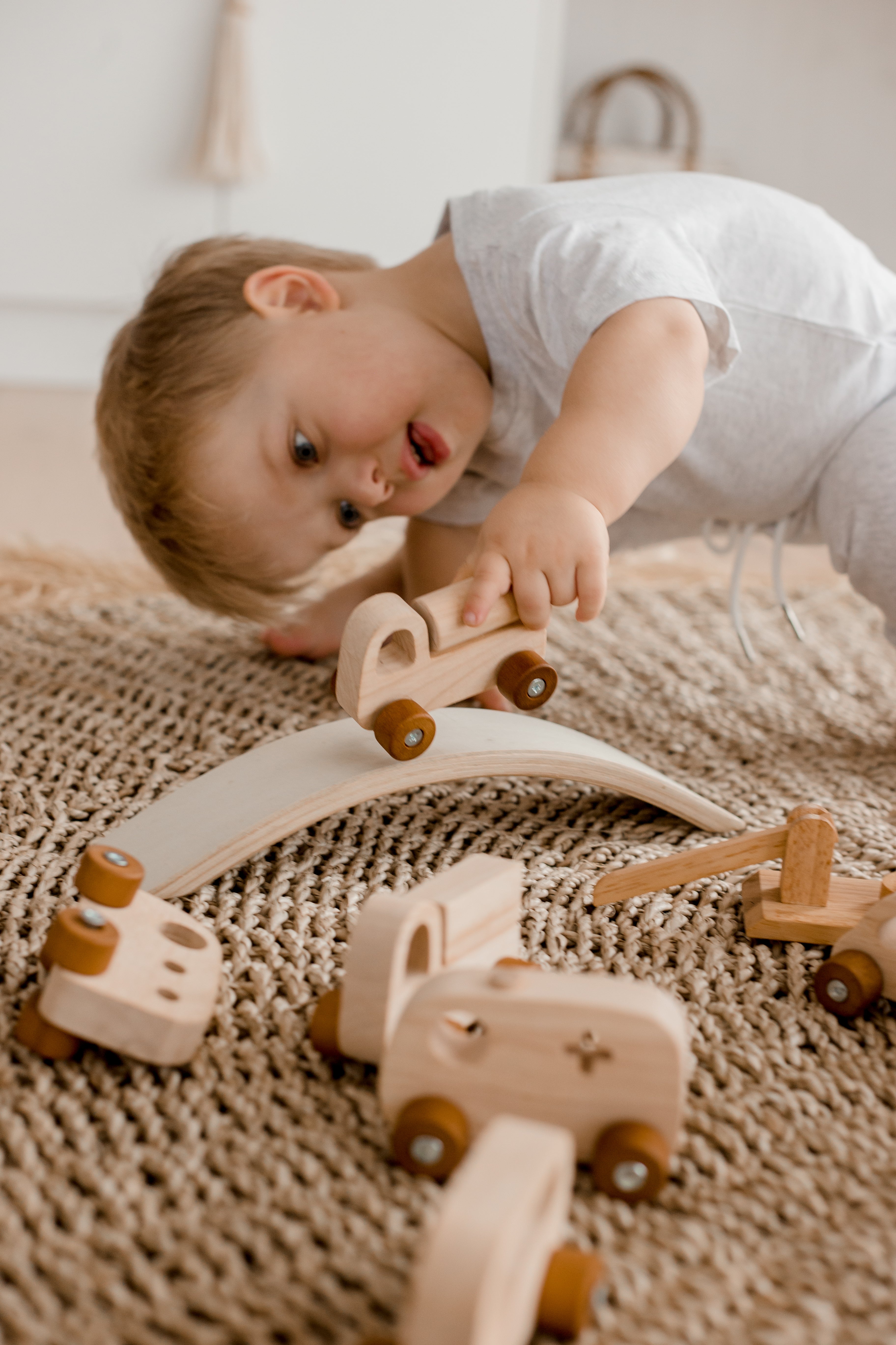 Boy driving his car over a bridge from wooden Vehicle play set from QToys